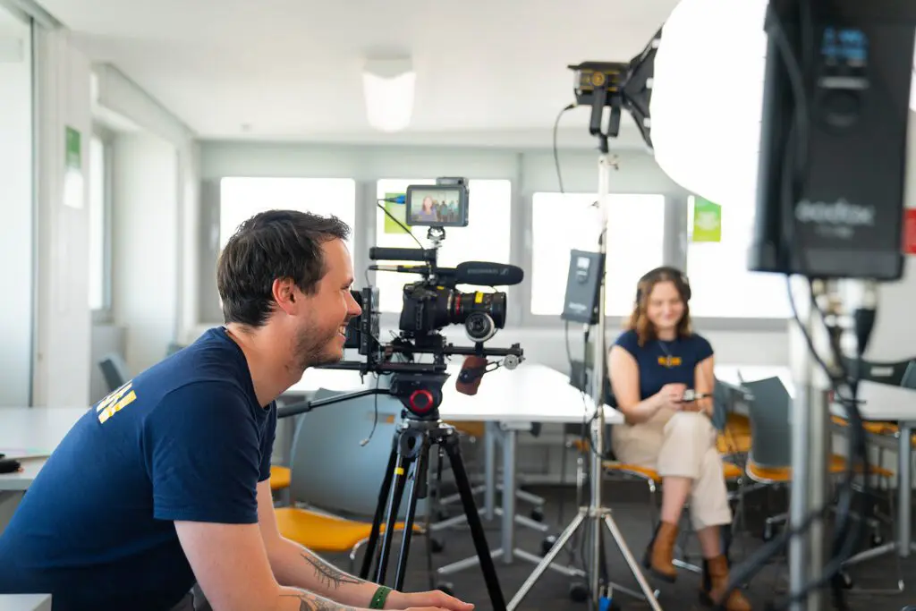 video production crew sat behind the camera and smiling