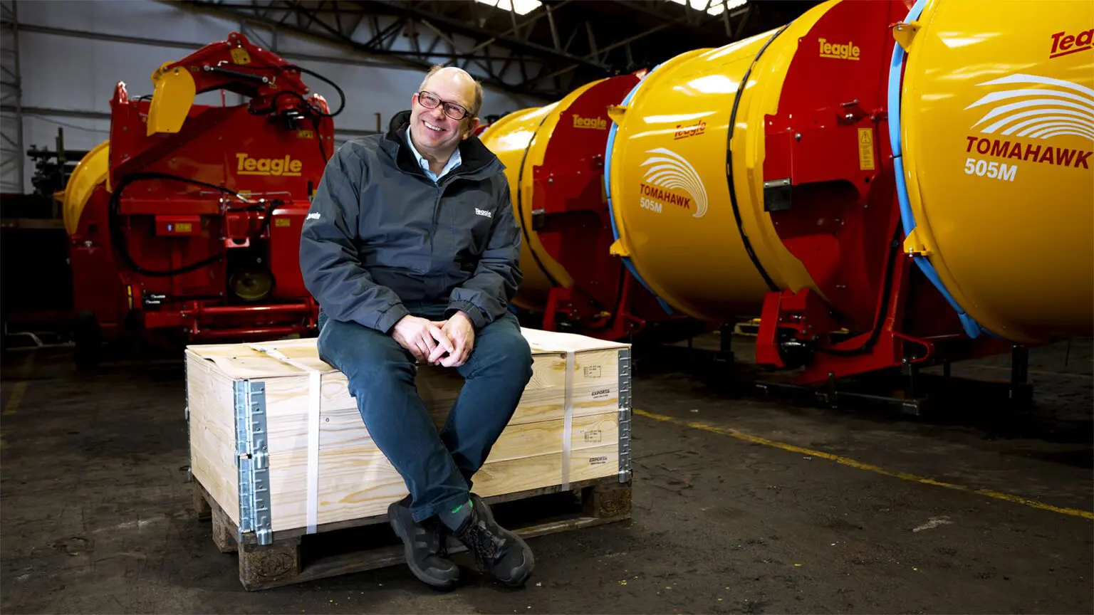 Teagle employee sat on wooden box smiling