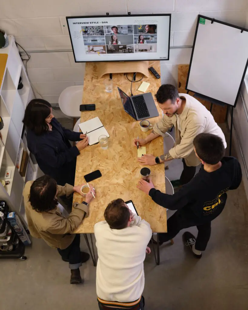 Shot from above of the Bull & Wolf team having a standing meeting at a desk