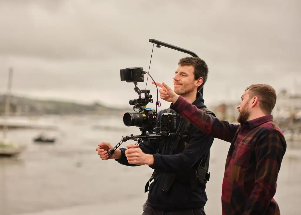 On set next to the river. Joe directing camera man looking at screen