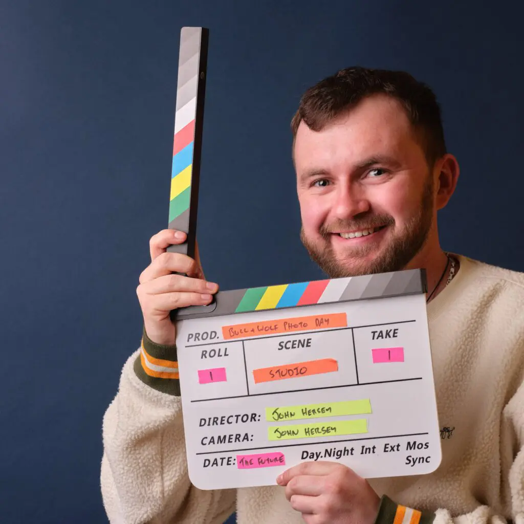 Joe from Bull & Wolf Smiling at camera with clapper board