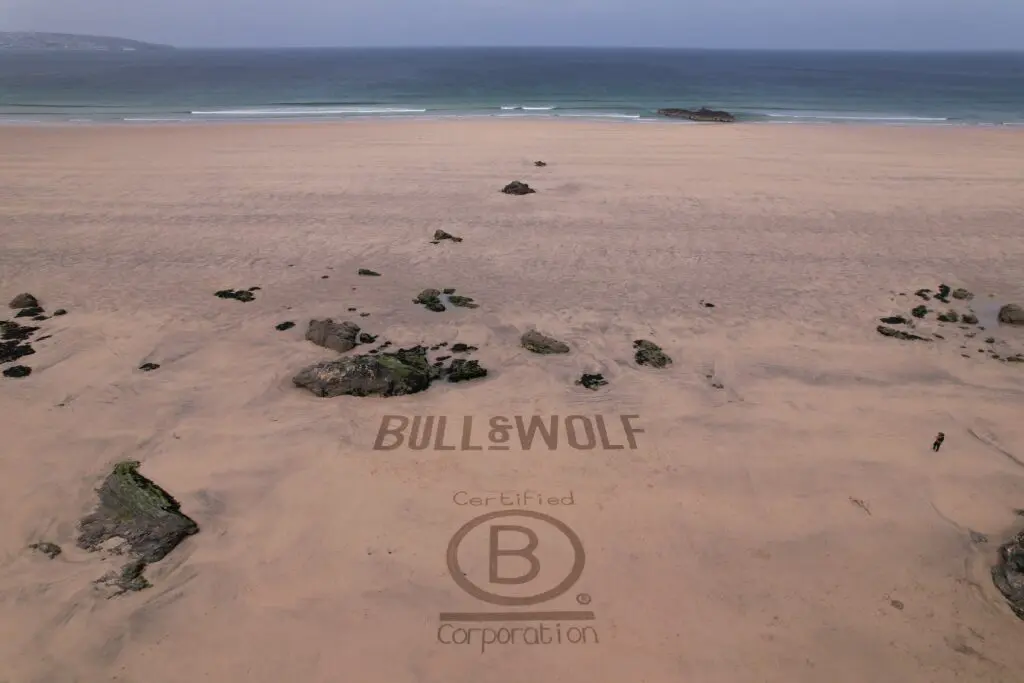 Beach with 'Bull & Wolf B Corp Certified' written in the sand