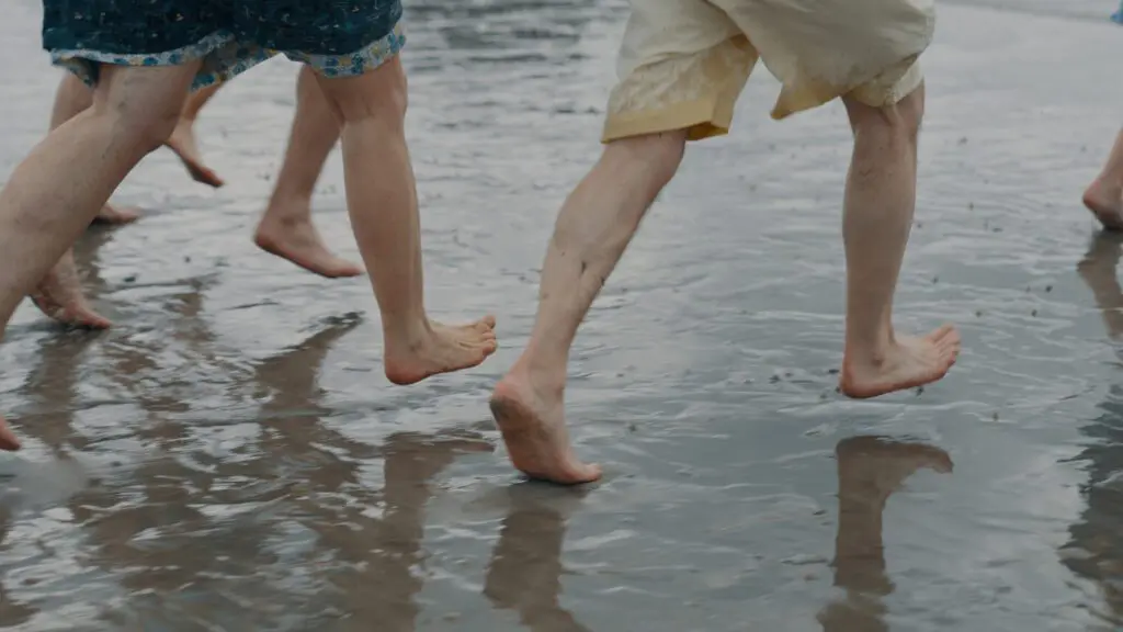 People running barefoot in the rain