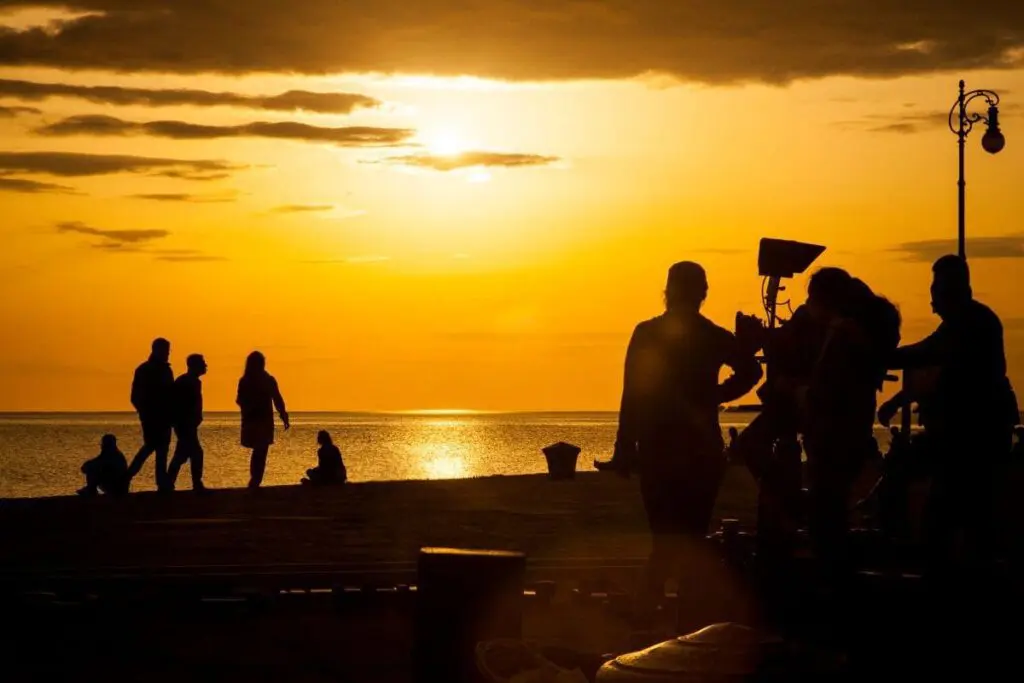 a silhouette of film crew uk filming on the beach 