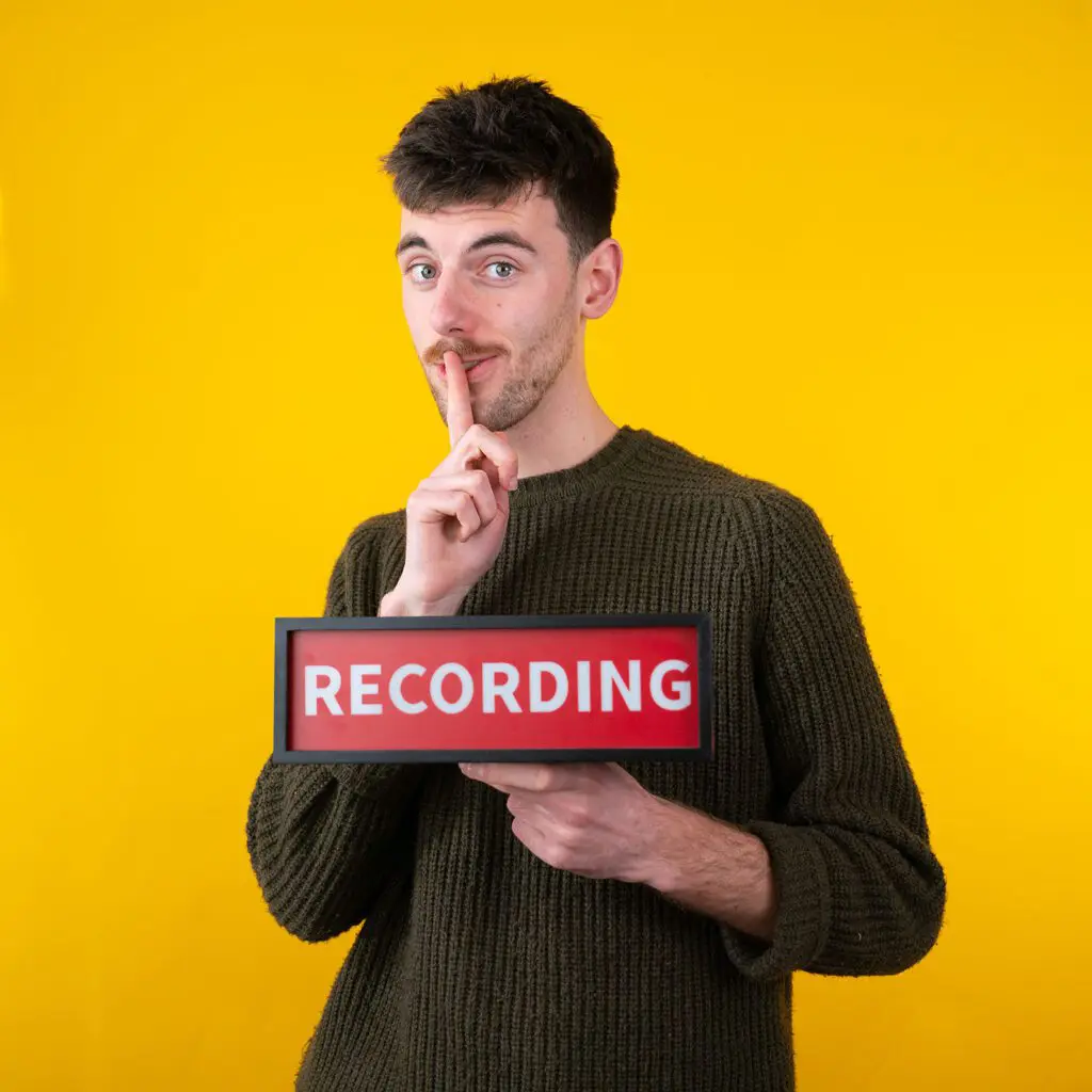 man_holding_branded_video_conten_recording_sign