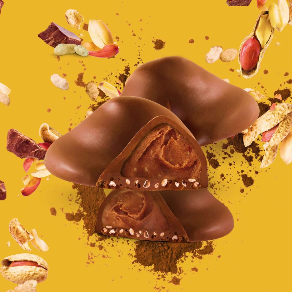 Still from animated clip of inside of Buttermilk caramel chocolate bar with fruit and nuts exploding around